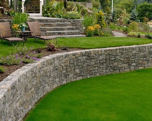 curved retaining wall with green grasss
